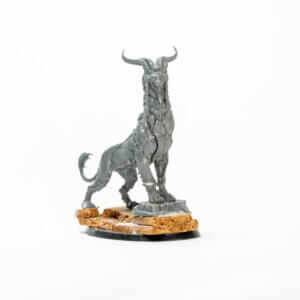 Unpainted miniature figure of a horned hellhound standing on a cork base on a white background