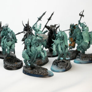 Group of turquoise fantasy miniatures in armor with spears and axes on rocky bases, arranged for tabletop gaming photography